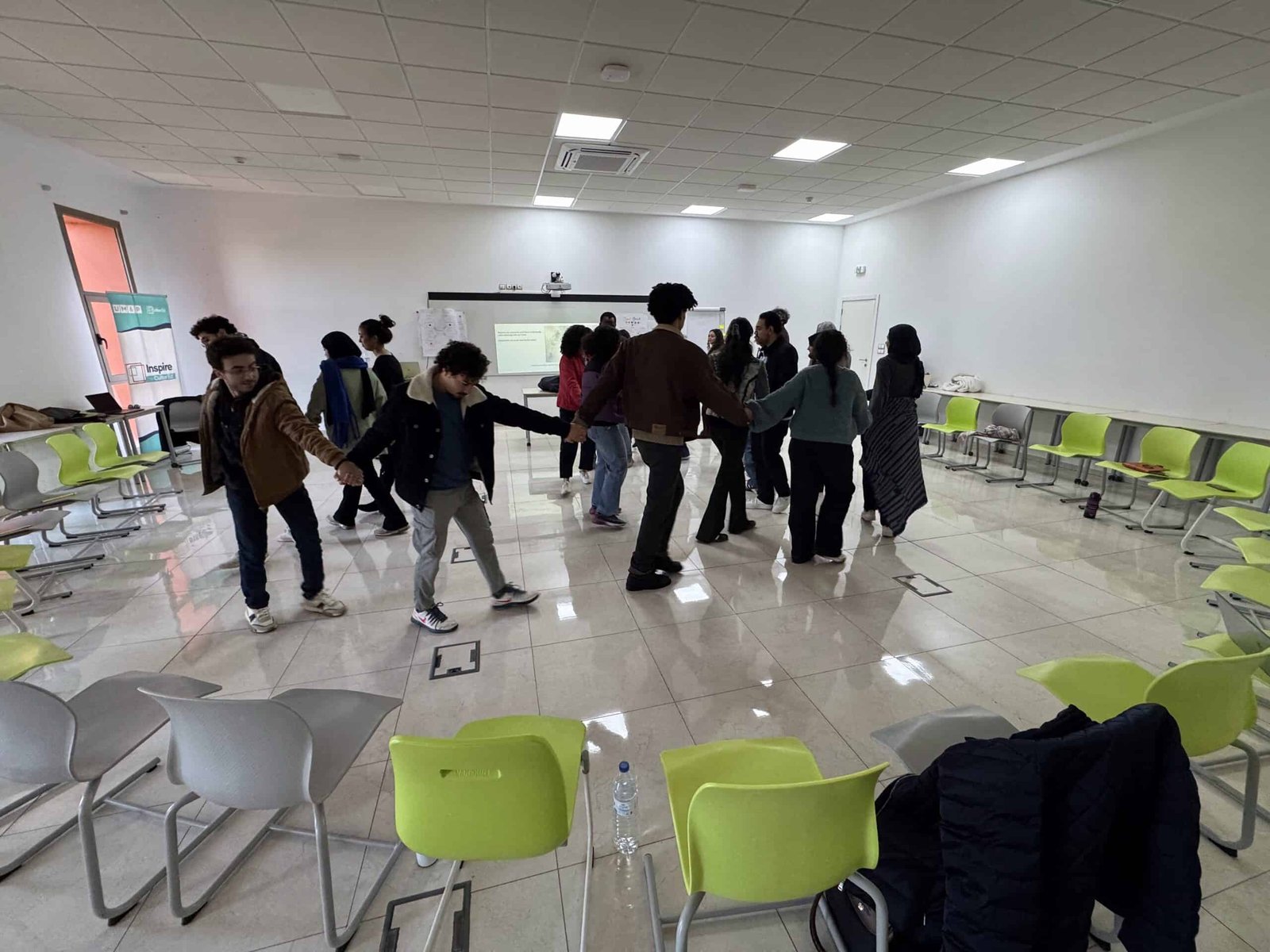 IMG_4442 University students in Morocco participating in a grounding and embodied group activity during a Transformative-Emancipatory Pedagogy (TEP) workshop, designed to foster presence, collective attunement, and self-care before engaging with sensitive topics.