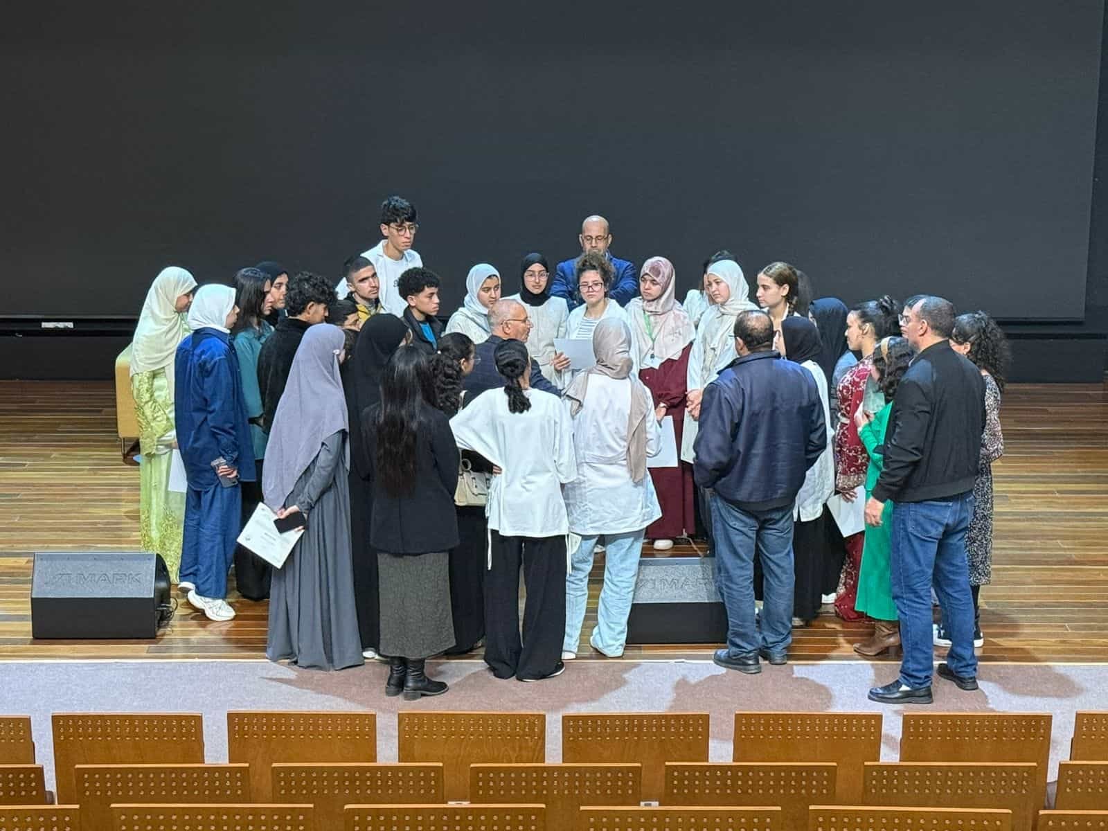 tep-lycee-mohammed-VI-excellence-certificate-ceremony-2026 Students from Lycée Mohammed VI d'Excellence gathered on stage with teachers and school staff at the conclusion of the first TEP pilot certificate ceremony, Benguerir, Morocco, March 2026.