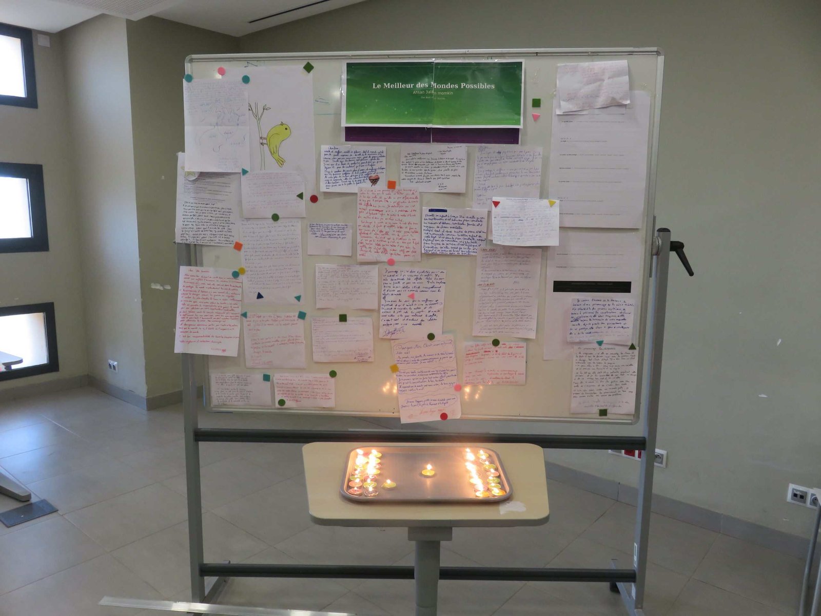 tep-pedagogy-of-hope-A Plea for a Better World-lycee-morocco-2026 A whiteboard covered in handwritten student letters titled "A Plea for a Better World", with candles lit on a table beneath it, created during the pedagogy of hope session of a Transformative-Emancipatory Pedagogy (TEP) pilot at Lycée Mohammed VI d'Excellence, Morocco, 2026.