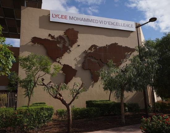 Entrance of the Lycée Mohamed VI d'Excellence Entrance of Lycée Mohammed VI d’Excellence (LM6E) in Benguerir, Morocco, featuring a large world map installation on the exterior wall.